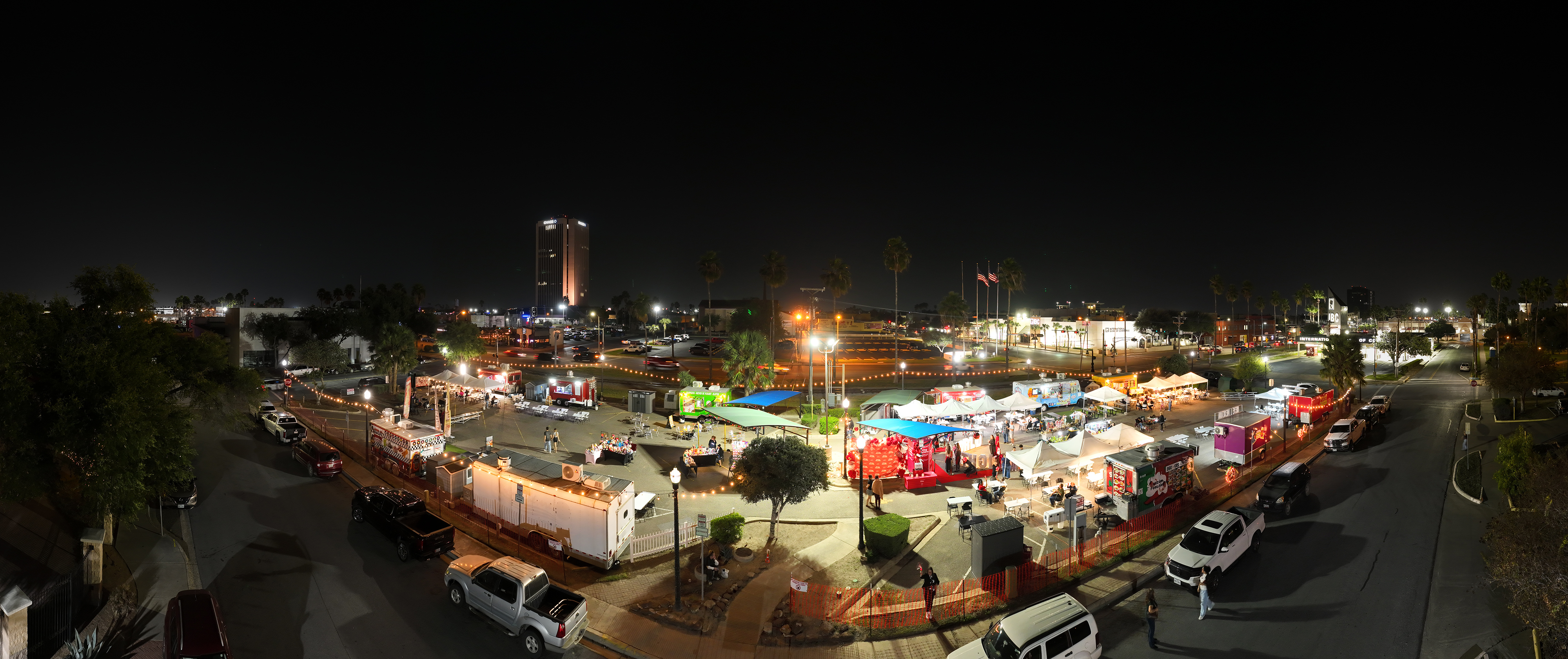 Aerial view of McAllen Food Park at night, food trucks and string lights